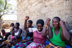 Women sitting together outdoors, encouraging each other during group talk therapy.