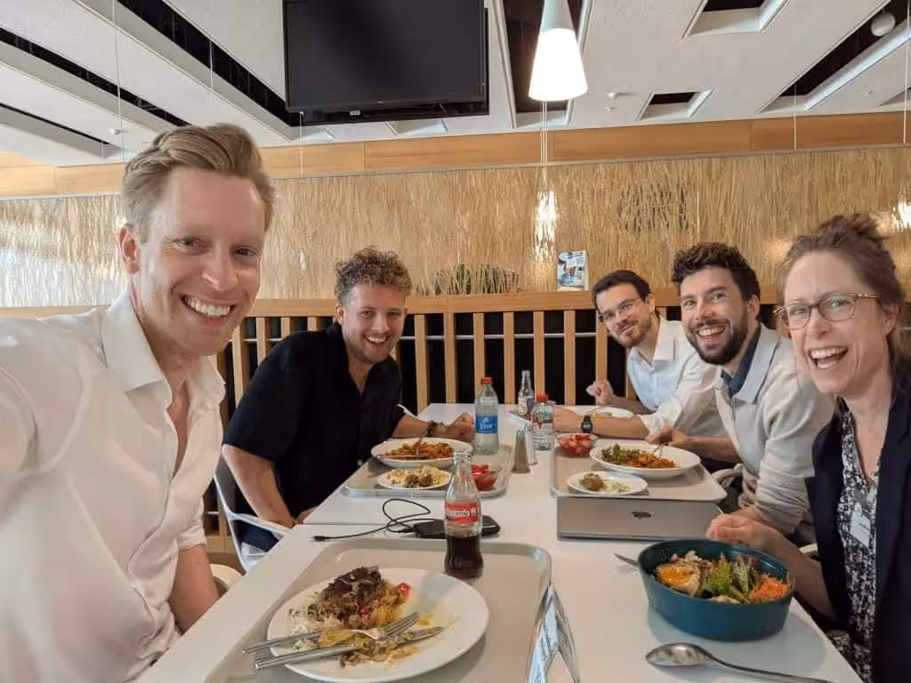 Team members from the Happier Lives Institute enhoying lunch together at a conference.