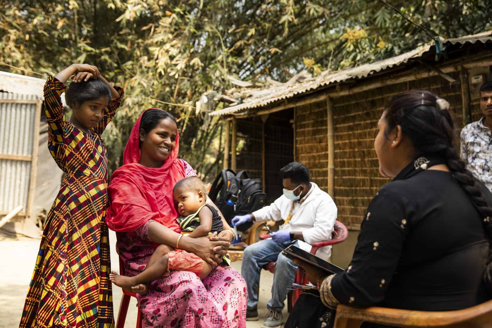 A mother with her children listening to a community health worker who is talking
about blood lead level testing.