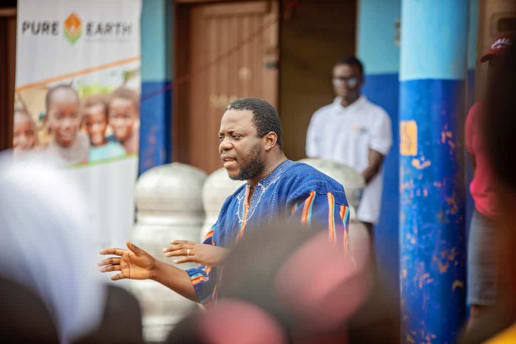 Esmond Quansah from Pure Earth Ghana addressing the audience at an awareness-raising event outdoors.