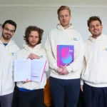 HLI research team holding the 2025 World Happiness Report in print.