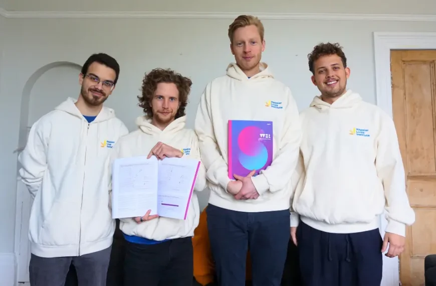 HLI research team holding the 2025 World Happiness Report in print.