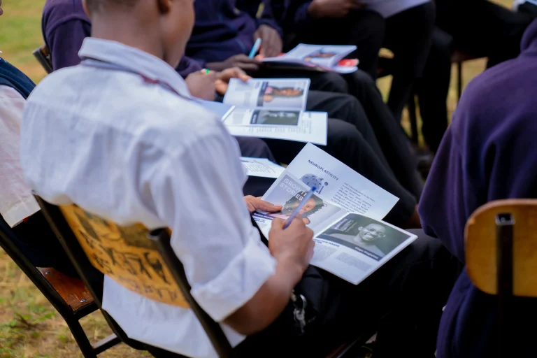 Close-up of a boy reading materials provided by the Shamiri Institute