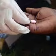 A healthcare worker giving a pill to a patient.
